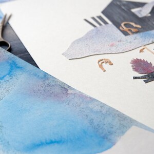 May include: An artistic composition featuring watercolor paper with blue and purple hues, alongside cut paper elements and a pair of scissors. The cutouts include abstract shapes and textures, suggesting a collage or mixed-media art project.