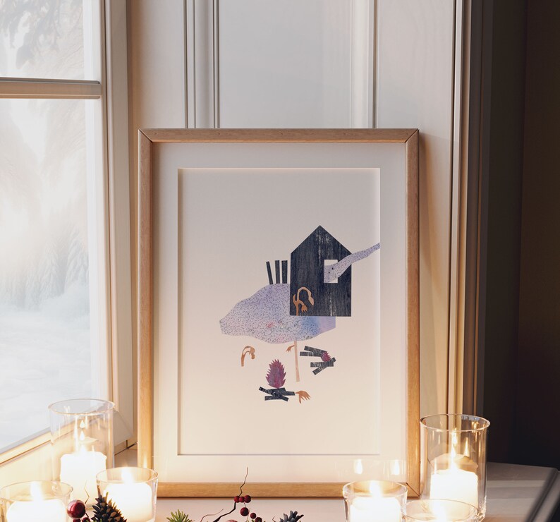 May include: A framed art print featuring a whimsical illustration of a dark blue house with a chimney, a purple and blue landscape, and a campfire. The artwork is displayed on a windowsill with lit candles in glass holders.