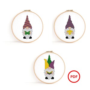 Peut inclure: Trois motifs de point de croix de gnomes portant des chapeaux sur le thème du Mardi Gras et tenant des objets sur le thème du Mardi Gras. Les motifs sont dans des cerceaux à broder.