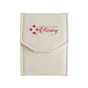 May include: A white faux leather rosary case with a red embroidered design that says "Your Custom Rosary".