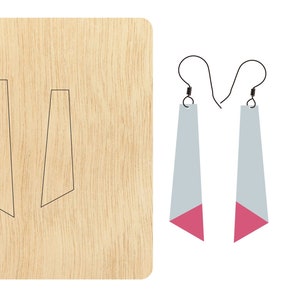 Puede incluir: Una plantilla de corte por láser para hacer pendientes. La plantilla muestra dos formas de pendientes, cada una con una parte inferior puntiaguda y una parte superior recta. La plantilla está hecha de madera.