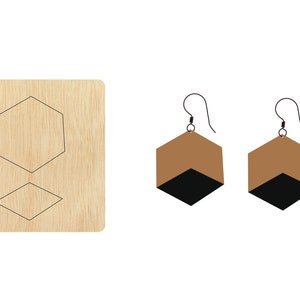 Puede incluir: Una plantilla de madera para hacer pendientes. La plantilla incluye dos formas: un hexágono y un diamante. La plantilla se muestra junto a dos pendientes terminados, que son marrones con detalles negros.