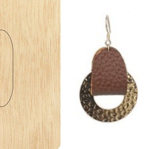 Puede incluir: Una plantilla de madera para hacer pendientes de cuero. La plantilla incluye dos formas: un círculo con un círculo más pequeño dentro y un óvalo. La plantilla se muestra junto a un par de pendientes terminados con una tira de cuero marrón y un anillo de metal dorado.
