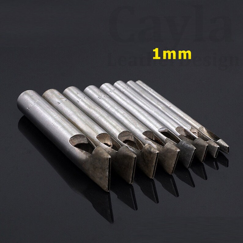 May include: A set of eight metal leather hole punches with different sizes. The punches are arranged in order of size, with the smallest punch on the left and the largest punch on the right. The punches are all made of metal and have a silver finish. The largest punch is labeled "1 mm".