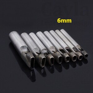 May include: Set of 9 metal leather hole punch tools with oval shaped holes. The tools are arranged in order of size, with the smallest tool on the left and the largest tool on the right. The largest tool is labeled "6mm".