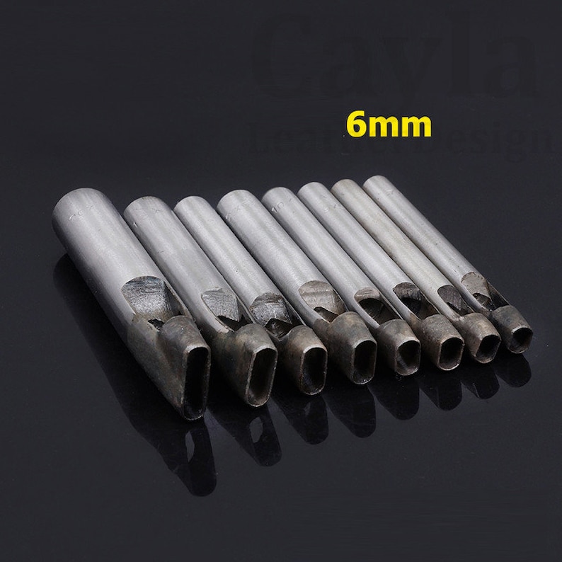 May include: Set of 9 metal leather hole punch tools with oval shaped holes. The tools are arranged in order of size, with the smallest tool on the left and the largest tool on the right. The largest tool is labeled "6mm".
