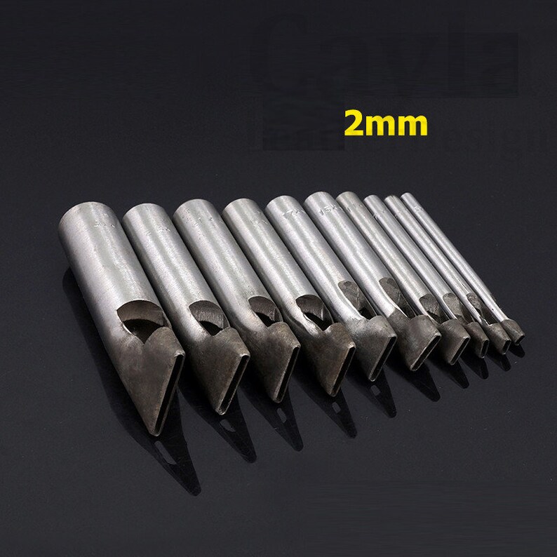 May include: A set of 10 metal leather hole punches with different sizes. The punches are arranged in order of size, with the smallest punch on the left and the largest punch on the right. The punches are all silver in color and have a sharp, pointed tip. The text "2mm" is visible in the image.