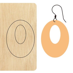 Puede incluir: Un par de pendientes de madera con forma ovalada grande y un recorte ovalado más pequeño en el centro. Los pendientes son de color marrón claro y tienen un gancho plateado.