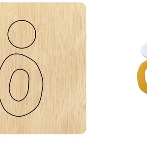 Puede incluir: Una plantilla de madera para hacer pendientes. La plantilla presenta dos formas ovaladas, una dentro de la otra, y un círculo más pequeño arriba.