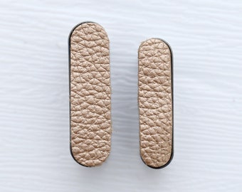 May include: Two gold leather drawer pulls with black trim.