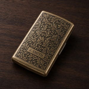 Puede incluir: Una pitillera rectangular de latón antiguo con un intrincado patrón floral en relieve en toda la superficie. Una placa rectangular horizontal central está grabada con el nombre J. SMITH en letras mayúsculas en la cubierta frontal.