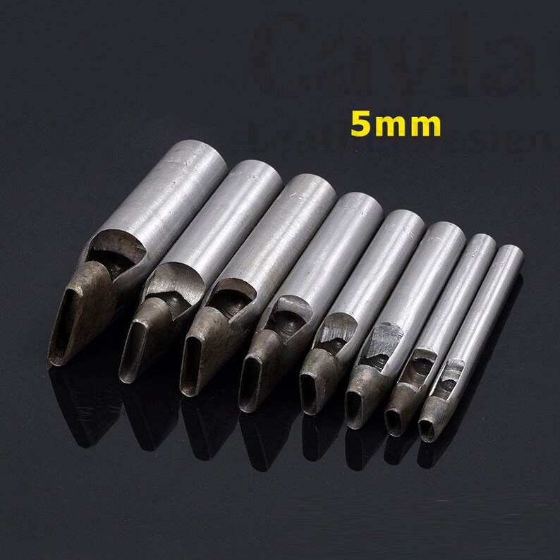 May include: Set of eight metal leather hole punches with oval-shaped blades. The punches are arranged in order of size, with the largest punch on the left and the smallest punch on the right. The largest punch is labeled "5mm".