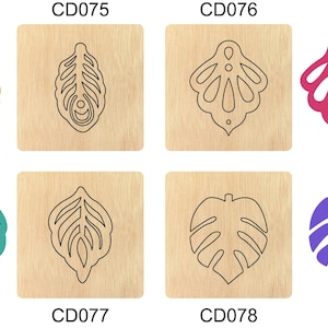Puede incluir: Cuatro troqueles de artesanía montados en madera para cortar diseños intrincados. Los troqueles presentan una pluma de pavo real, un diseño floral, una hoja y una hoja de monstera. Los troqueles están etiquetados como CD075, CD076, CD077 y CD078.