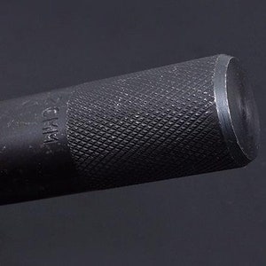 May include: A black metal punch tool with a textured handle and a 25mm hole. The tool is designed for punching holes in metal.