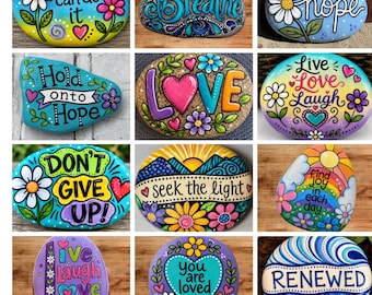 May include: A digital collage of twelve painted rocks featuring colourful floral designs, hearts, and inspirational text such as You can do it, Breathe, Hope, Hold onto Hope, LOVE, Live Love Laugh, DON'T GIVE UP, seek the light, find joy, and RENEWED.