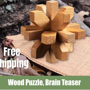 May include: A wooden puzzle in the shape of a star with multiple points. The puzzle is made of light brown wood and is sitting on a burlap sack. The text "Free Shipping" is visible in the image. The text "Wood Puzzle, Brain Teaser" is visible at the bottom of the image.