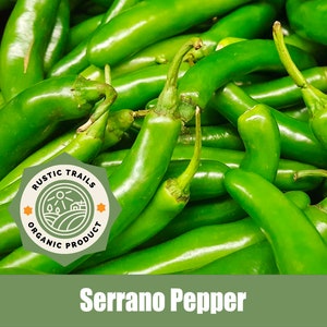 May include: A close-up image of a pile of bright green Serrano peppers. The peppers are fresh and have a slightly pointed shape. A sticker with the text "Rustic Trails Organic Product" is visible in the lower left corner of the image. The text "Serrano Pepper" is displayed in the lower center of the image.