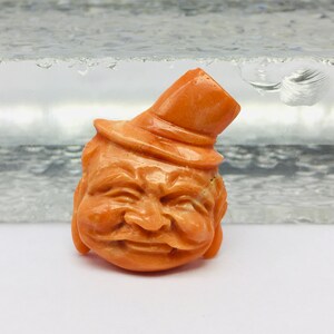 Natural CORAL/Hand carved FACE/Width 20MM/Length 25MM/Height 8MM/Weight 22.90 carats/Beautiful deep orange color/Face carving/Fancy carving