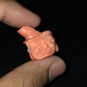 Natural CORAL/Hand carved FACE/Width 20MM/Length 25MM/Height 8MM/Weight 22.90 carats/Beautiful deep orange color/Face carving/Fancy carving