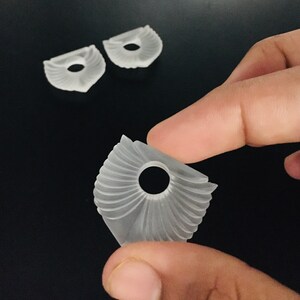 Puede incluir: Tres piezas decorativas de pl&aacute;stico blanco con un dise&ntilde;o en forma de abanico y un agujero circular en el centro. Las piezas son transl&uacute;cidas y tienen un acabado liso y brillante.