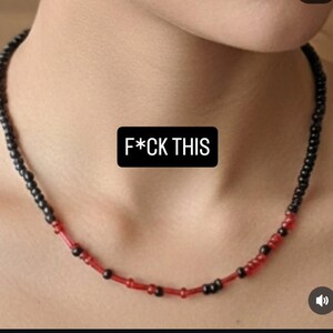 May include: A necklace made of black and red beads. The image includes the text "F*CK THIS" in white font on a black background.