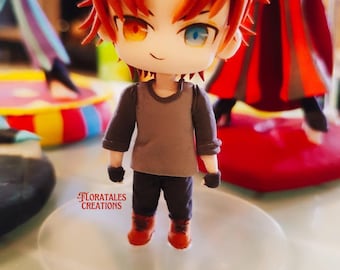 Könnte beinhalten: Eine kleine, handgefertigte Figur eines Charakters mit orangefarbenem Haar, einem grauen Shirt, einer schwarzen Hose und roten Schuhen. Die Figur hat einen freundlichen Ausdruck mit gelben und blauen Augen. Die Figur steht auf einem durchsichtigen Plastiksockel.