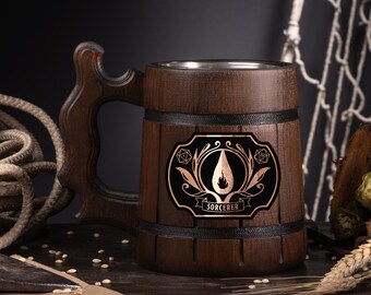May include: A dark brown wooden beer mug with a decorative handle and a metal interior. The mug features a black and copper emblem with the word "SORCERER" and a flame design. The mug is surrounded by rope, wheat, and hops.
