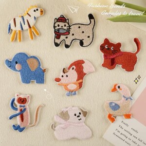 May include: A set of ten embroidered iron-on patches featuring various animals, including a zebra, cat, elephant, fox, dog, monkey, and goose. The patches are colorful and whimsical, perfect for adding a touch of personality to clothing, bags, or other fabric items.