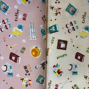 May include: Two fabric swatches with a repeating pattern of coffee-themed illustrations. The left swatch is pink with illustrations of coffee cups, pastries, and a coffee shop. The right swatch is cream with illustrations of coffee cups, pastries, and a coffee shop. Both swatches have the word "Coffee" printed on them.