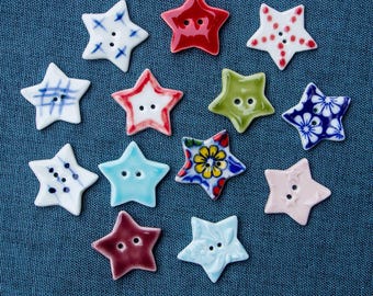 May include: A collection of 12 ceramic star-shaped buttons in various colors and patterns. The buttons feature different designs, including floral, geometric, and abstract patterns.