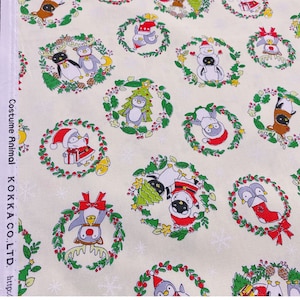 May include: White fabric with a repeating pattern of penguins wearing different holiday costumes. The penguins are surrounded by wreaths with red berries and green leaves. The fabric has the text "Costume Animal KOKKA CO., LTD. http://"