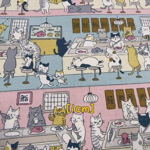 May include: A colorful fabric with a repeating pattern of cats eating sushi at a restaurant. The fabric features a light blue background with pink and yellow accents. The cats are depicted in various poses, some sitting, some standing, and some lying down. The fabric also features Japanese characters and a sign that reads "[cm]".