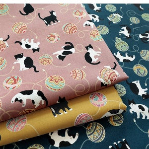 May include: Three fabric swatches featuring a repeating pattern of black and white cats playing with colourful yarn balls. The fabrics are pink, yellow and teal.