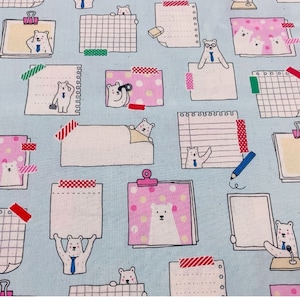 May include: A blue fabric with a repeating pattern of white polar bears and various sized white paper notes with different colored washi tape accents. Some of the notes have grid lines, some have lines, and some are blank.