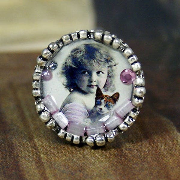 Bague en résine et métal couleur argentée avec une illustration de petite fille des années 1900