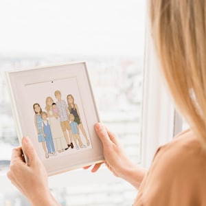 A woman holding a  high quality personalized hand drawn family portrait. The artwork displays a happy and funny family in a unique cartoon style. A meaningful keepsake for the Mother's Day or for the Father's Day