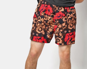 May include: Red, orange, and black patterned swim trunks with the word "adidas" on the right leg.