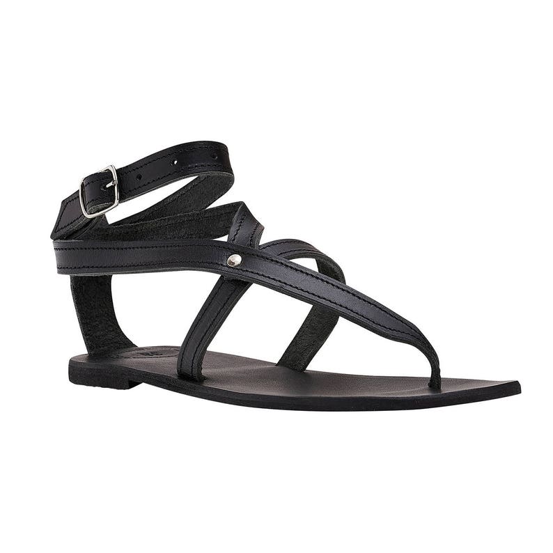 May include: Black leather sandals with a buckle strap and multiple straps across the foot. The sandals have a flat sole.