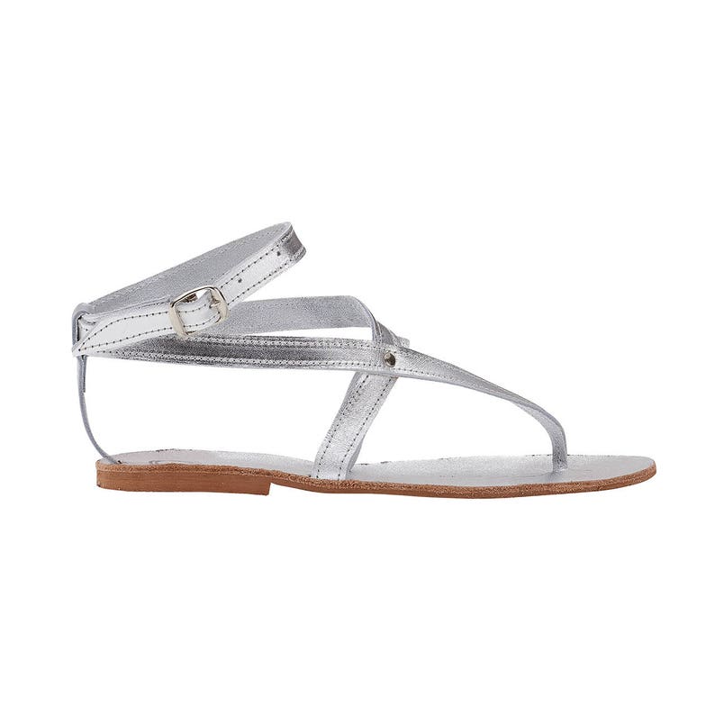 May include: Silver leather sandals with a buckle closure and criss-cross straps.