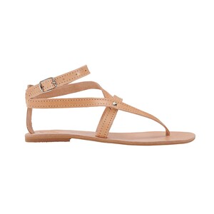 May include: Tan leather sandals with a buckle closure and multiple straps. The sandals have a flat sole.