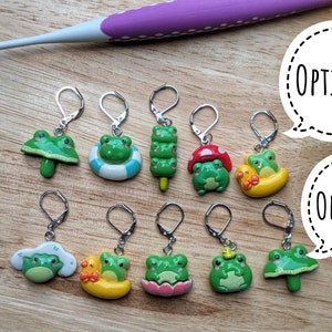 Peut inclure: Un ensemble de 10 marqueurs de points en forme de grenouille pour le tricot ou le crochet. Les marqueurs présentent différents motifs de grenouilles, notamment une grenouille sur un champignon, une grenouille sur un nénuphar, une grenouille sur un nuage et une grenouille sur une bouée de sauvetage. Les marqueurs sont en métal et ont une finition argentée.