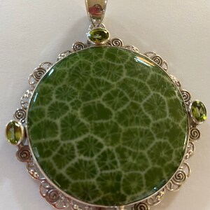 Fossil shell and peridot pendant set in 925 sterling silver
