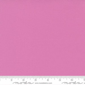 May include: A solid pink fabric swatch with a ruler showing measurements in inches.