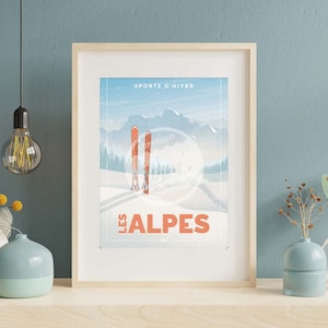 Könnte beinhalten: Ein Vintage-Poster mit einer blauen und weißen Bergszene. Das Poster zeigt zwei rote Skier und den Text "SPORTS D'HIVER LES ALPES".