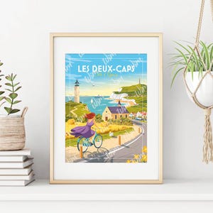 Peut inclure: Impression d'art encadrée présentant une illustration de style affiche de voyage vintage. L'œuvre représente une personne à vélo sur une route côtière, avec un phare et des bâtiments en arrière-plan. Le texte "LES DEUX-CAPS" est en haut.