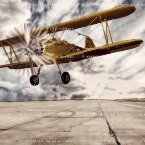May include: A yellow biplane airplane with a propeller in flight against a cloudy sky. The airplane has the number 218 on the side.