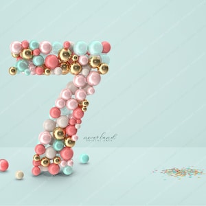 Peut inclure: Le chiffre sept est composé de sphères rose pastel, bleues et dorées. Le chiffre est sur un fond bleu clair avec un petit tas de confettis en bas à droite.