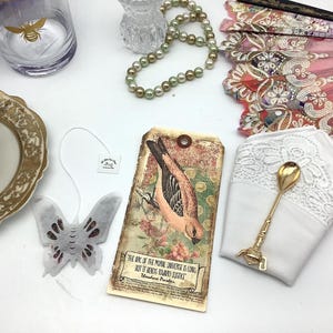Tee Geschenk. Vintage Carta Postale Vogel-Postkarte, schwarzer Tee und Rosen-Schmetterlingstee, gestickte Serviette und vergoldeter Teelöffel