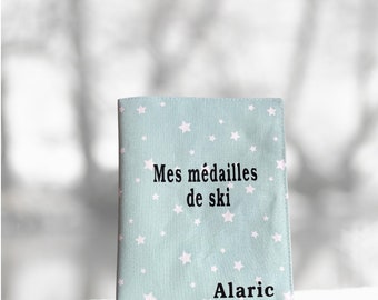 Pochette pour medailles de ski vert d’eau avec étoiles