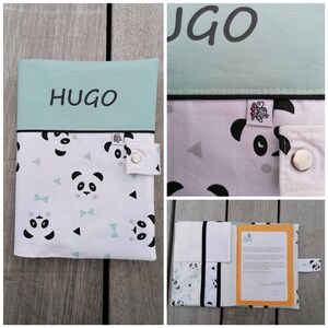 Peut inclure: Une couverture de livre bleu clair avec un motif de panda noir et le nom "HUGO" imprimé sur le devant. La couverture a un rabat noir avec une fermeture à bouton.